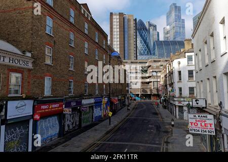 Modern high rise buildings of London's Financial centre soar above the graffitti embossed periphery of Wentworth Street in Shoreditch London Stock Photo