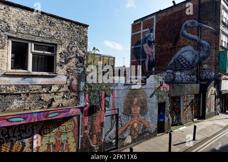 The colorful graffitti along Hanbury Street off Brick Lane in Shoreditch brightens up what  is a pretty run down area Stock Photo