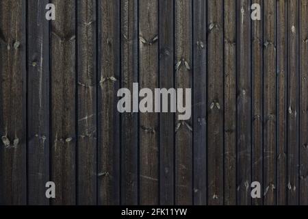 Texture of dark barn wall made from homemade rough sawn timber. Knotty boards treated with varnish and pine tar. Stock Photo
