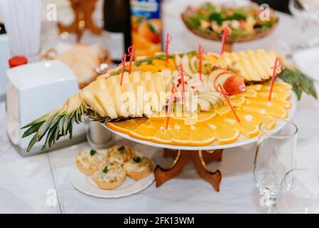 Dish with pineapple and orange slicing. Fruit plate with beautifully cut oranges and pineapple Stock Photo