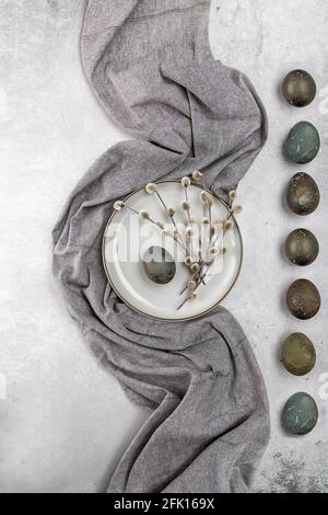 Easter picture with painted eggs on a plate. Willow branch. The minimal concept of Easter. An Easter card with a place for the text. Stock Photo