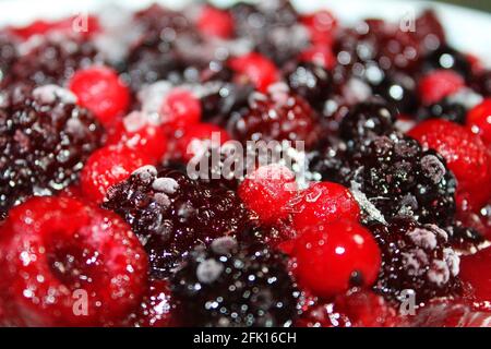 Close-up of a frozen mixed berry cheesecake, with a slight skim of ice and frost on the berries. Stock Photo