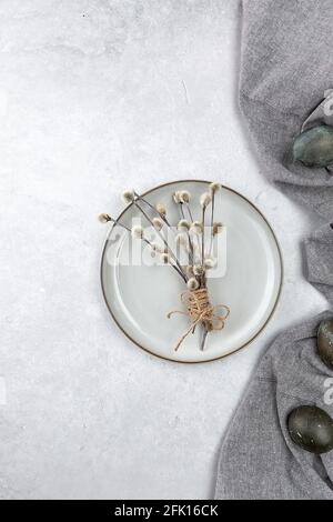 Easter picture with painted eggs on a plate. Willow branch. The minimal concept of Easter. An Easter card with a place for the text. Stock Photo