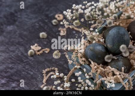 Easter composition with dark colored eggs in a wooden box. Willow branch. The minimal concept of Easter. An Easter card with a place for the text. Stock Photo
