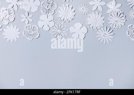 Creative layout with variety of white paper flowers over gray background. Flat lay, copy space Stock Photo