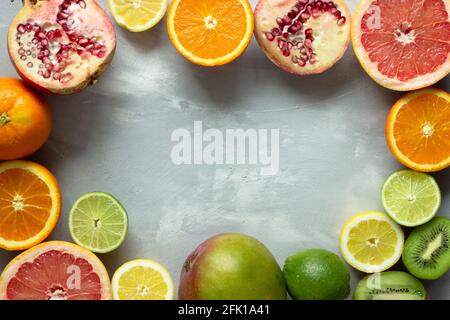 Tropical and exotic colorful fruits in a circle on gray background with copy space; juicy fresh fruit Stock Photo