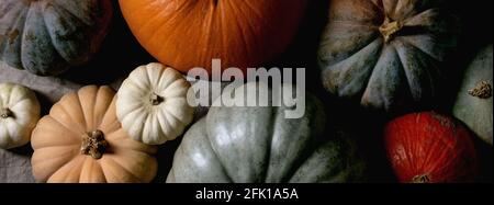 Colorful pumpkins collection different size and cultivars on linen tablecloth. Flat lay. Autumn harvest. Banner size Stock Photo