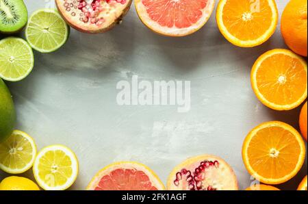 Tropical and exotic colorful fruits in a circle on gray background with copy space; juicy fresh fruit Stock Photo