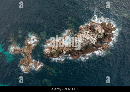 Guano from nesting seabirds covers rocks off Lands End, West Cornwall, UK Stock Photo