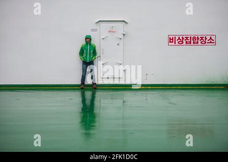 woman leaning against the wall on the Ferry to Jeju Island Stock Photo