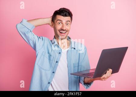 Photo portrait amazed surprised programmer keeping laptop staring smiling isolated pastel pink color background Stock Photo