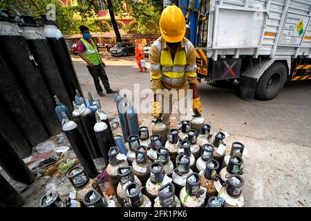 Kolkata, India. 27th Apr, 2021. Workers loading & unloading oxygen cylinders at a government hospital.Hospitals in India are running out of oxygen supply for the Covid-19 patients during the second wave of Covid-19 pandemic. Credit: SOPA Images Limited/Alamy Live News Stock Photo