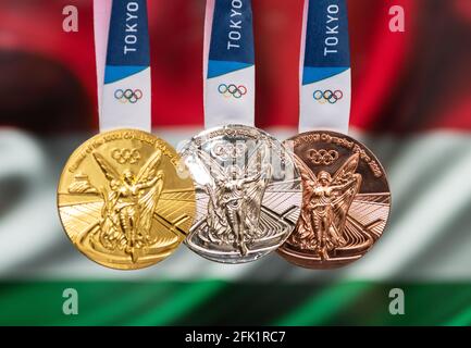 April 25, 2021 Tokyo, Japan. Gold, silver and bronze medals of the XXXII Summer Olympic Games 2020 in Tokyo on the background of the flag of Hungary. Stock Photo