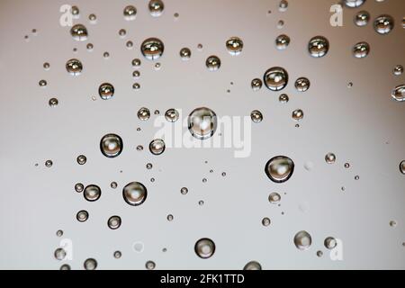 Drops of water from rainning on glass. Selective focus. white gray clouds background pattern texture. Stock Photo