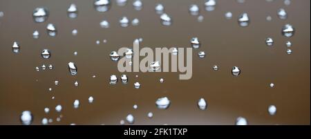 Drops of water from rainning on glass. Selective focus. white gray clouds background pattern texture. Stock Photo