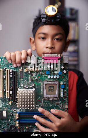 Student boy Studying and repairing Pc motherboard in the Computer Lab Stock Photo