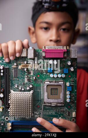Student boy Studying and repairing Pc motherboard in the Computer Lab Stock Photo