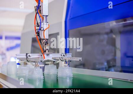 Stack of food containers on conveyor belt of plastic injection molding machine Stock Photo