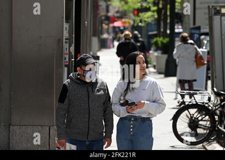 People are seen walking through the streets of Manhattan while wearing masks as other choose not to wear a face covering on the day The Centers for Disease Control and Prevention eased its guidelines on wearing masks outdoors, saying only fully vaccinated people do not need to cover their faces unless in a large crowd, New York, NY, April 27, 2021. A growing number of people who have received their first dose of vaccine are not going back for their second shot, reducing the efficacy of the vaccine and compromising their immunity to COVID-19.  (Photo by Anthony Behar/Sipa USA)