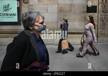 People are seen walking along 42nd Street, some with masks and others without, as The Centers for Disease Control and Prevention eased its guidelines on wearing masks outdoors, saying only fully vaccinated people do not need to cover their faces unless in a large crowd, New York, NY, April 27, 2021. A growing number of people who have received their first dose of vaccine are not going back for their second shot, reducing the efficacy of the vaccine and compromising their immunity to COVID-19.  (Photo by Anthony Behar/Sipa USA)