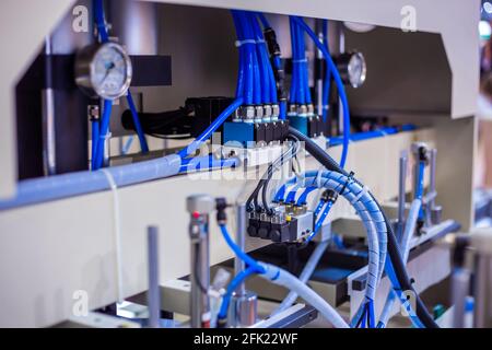 Part of automatic injection molding machine and plastic hoses at exhibition Stock Photo