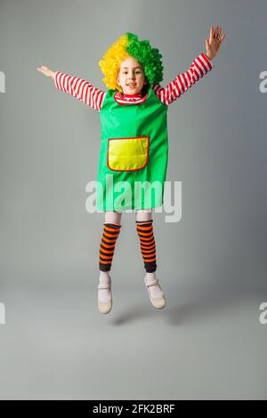 The little girl jumps in a clown uniform Stock Photo