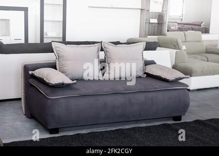 Small fabric couch in gray color with pillows Stock Photo