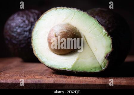an avocado fruit on a wooden board Stock Photo