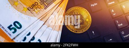Golden bitcoin over Euro money. Bitcoin cryptocurrency. Crypto currency concept. Bitcoin with euro bills. Bitcoins stacked on euro banknotes. Computer Stock Photo