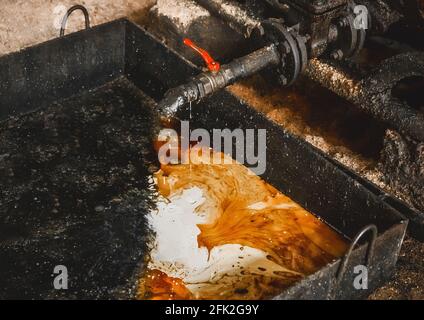 Drain oil-condensate mixture from an air compressor at an industrial plant. Stock Photo