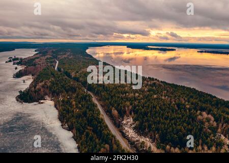 Aerial view of Karelia nature landscape with rivers and island with pine trees in spring evening. Stock Photo