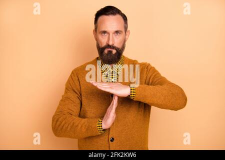Photo of strict focused man show time out gesture look camera wear cardigan isolated beige background Stock Photo