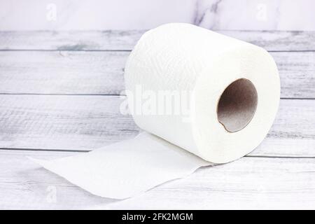 White toilet paper roll on light gray wooden background. Stock Photo