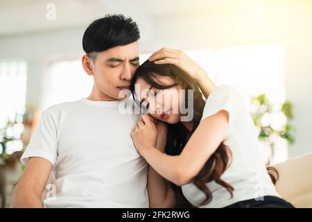 Depressed young woman  crying while her boylfriend come and embrace her Stock Photo