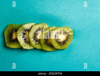 appetizing slice of kiwi on a blue background lies Stock Photo