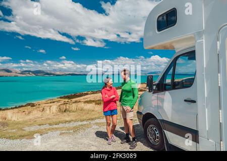 RV motorhome camper van road trip on New Zealand. Young couple on travel vacation adventure. Two tourists looking at Lake Pukaki and mountains on pit Stock Photo