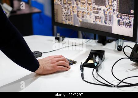 Engineer using a digital microscope for inspection of printed circuit boards (PCB) before soldering. Selective focus. Stock Photo