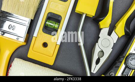 different hand tools for construction and repair. closeup top view on dark grey background. Stock Photo
