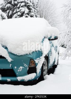 Passenger car in driveway covered by thick snow Stock Photo