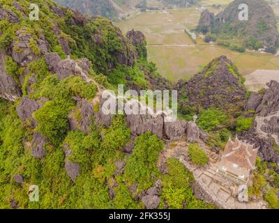Amazing huge dragon statue at limestone mountain top near Hang Mua view point at foggy morning. Popular tourist attraction at Tam Coc, Ninh Binh Stock Photo