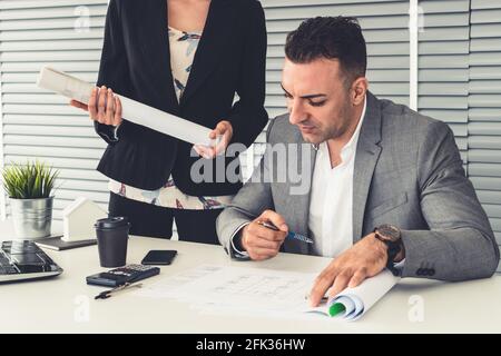Businessman executive checking work while meeting discussion with businesswoman worker in modern workplace office. People corporate business team Stock Photo