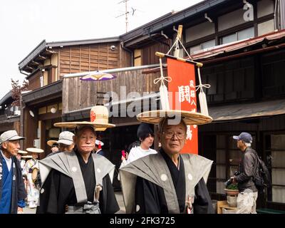 Takayama, Japan - October 10, 2015: Local people in traditional costumes marching the streets of historic Takayama during the annual Takayama Autumn F Stock Photo