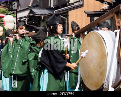 Takayama, Japan - October 10, 2015: Young local performer in traditional costume beating on a ritual drum during the annual Takayama Autumn Festival p Stock Photo