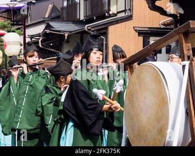 Takayama, Japan - October 10, 2015: Young local performer in traditional costume beating on a ritual drum during the annual Takayama Autumn Festival p Stock Photo