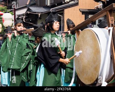 Takayama, Japan - October 10, 2015: Young local performer in traditional costume beating on a ritual drum during the annual Takayama Autumn Festival p Stock Photo