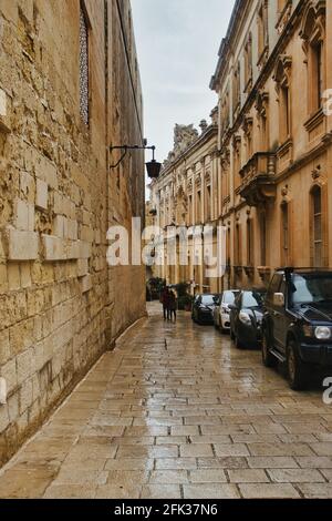 Mdina, Malta - October 12, 2020: Cars and buildings lined up on a narrow street in Mdina, Malta on a rainy day. Stock Photo