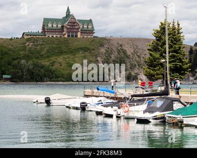 Waterton Lakes National Park, Canada - July 6, 2016: Waterton Townsite waterfront and historic Prince of Wales hotel under stormy sky Stock Photo