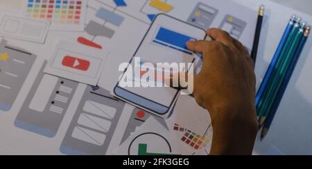 Designers drawing mobile ux app development concept. Man hold pencil with mockup ui. Stock Photo