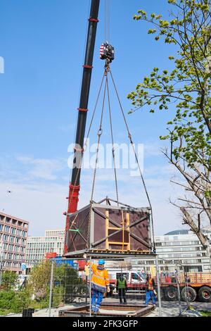 Berlin, Germany. 28th Apr, 2021. A packed medieval latrine is lifted by a heavy-duty crane on Fischerinsel. The 14th century latrine, discovered during archaeological excavations in 2016, is being moved from the original site to temporary storage. It will be open to the public for viewing in a pavilion once the new construction work is completed. Credit: Annette Riedl/dpa/Alamy Live News Stock Photo