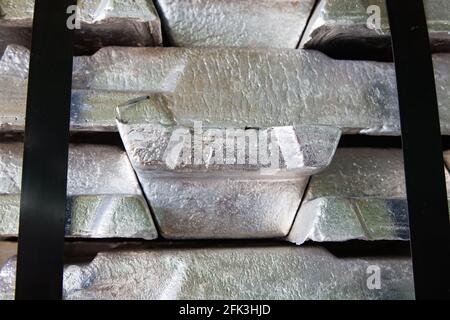 Stack of raw aluminum ingots (bars) in aluminum wire factory. Close up view. Stock Photo